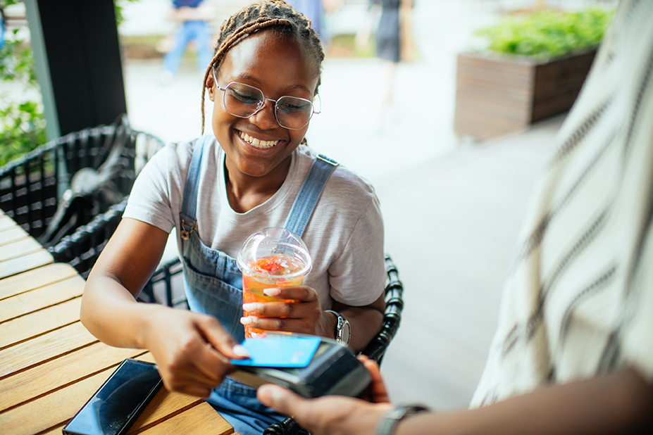 a woman smiling as she uses a credit card