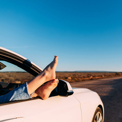 pair of feet sticking out of a car window