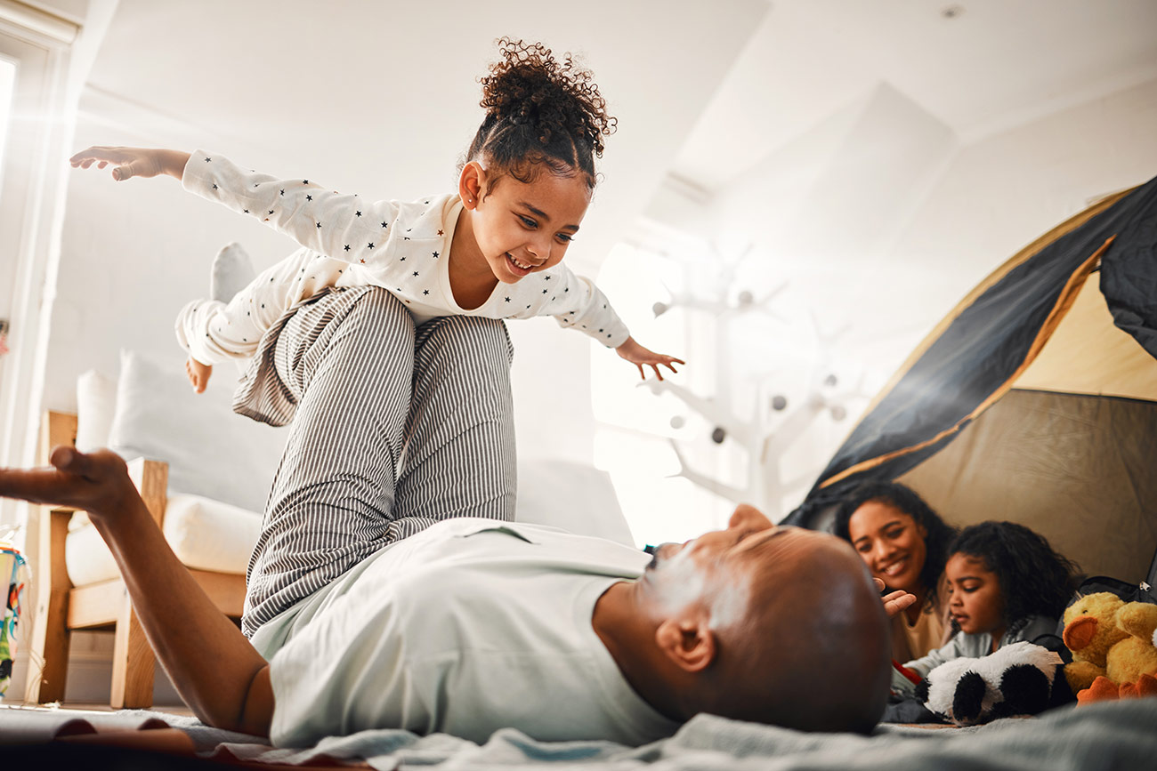 dad balancing daughter in the air like she's an airplane