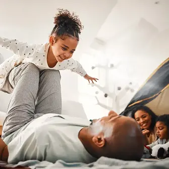 dad balancing daughter in the air like she's an airplane