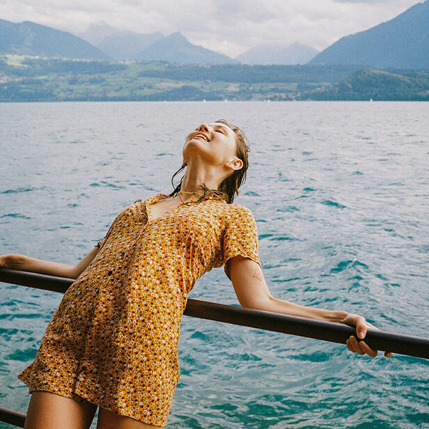 smiling woman leaning over a railing