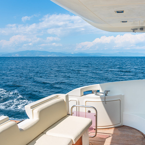 a white and brown boat with a view of the ocean