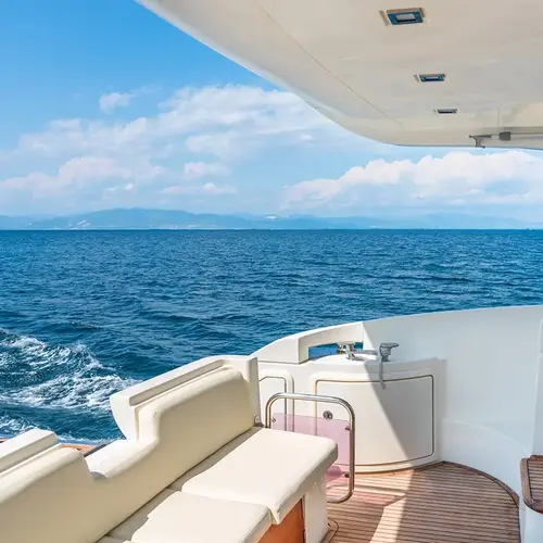 a white and brown boat with a view of the ocean