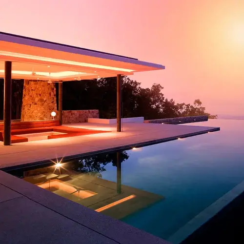 a pool with a building and a sunset