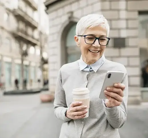 Elderly woman in the city using a smart phone