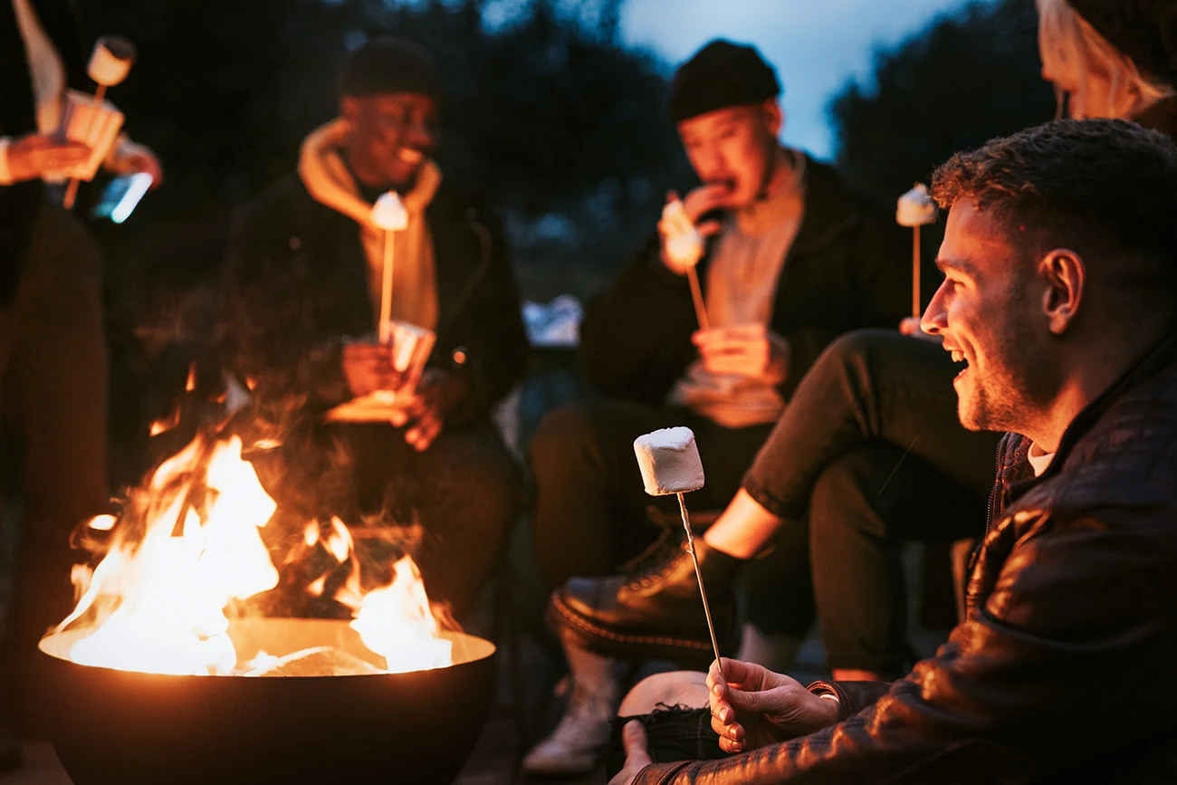 smiling people roasting marshmallows