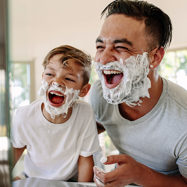 a man and boy with shaving cream on their faces