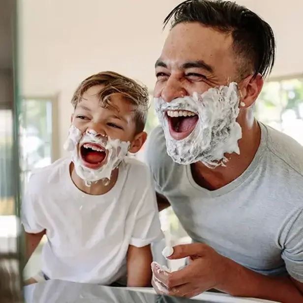 a man and boy with shaving cream on their faces