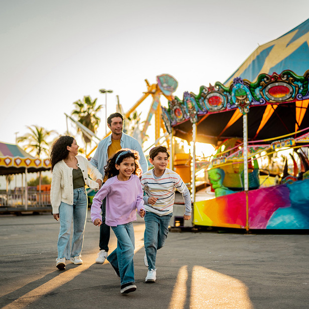 a group of people walking in front of a carnival ride