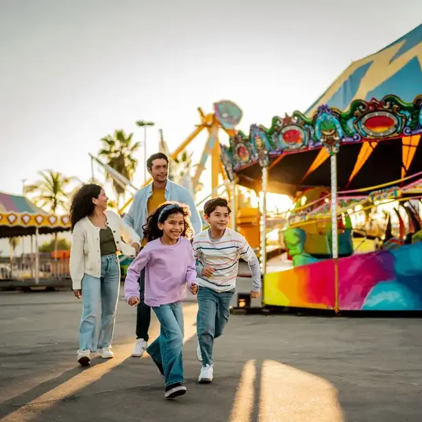 a group of people walking in front of a carnival ride