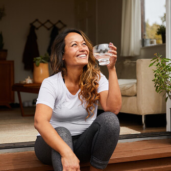 a woman sitting on a step drinking water