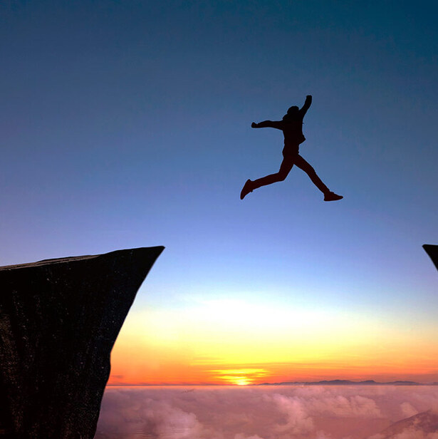a person jumping over a cliff